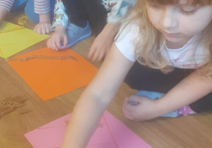 Dzieci układają makaron według określonego wzoru.